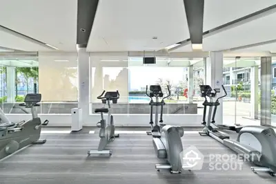 Modern gym with exercise equipment and pool view in luxury residential building