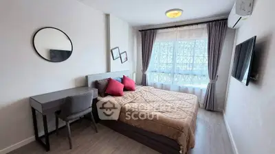 Cozy bedroom with modern decor, featuring a large window and stylish furnishings.