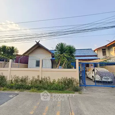 Charming suburban house with lush greenery and secure gated parking, perfect for family living.