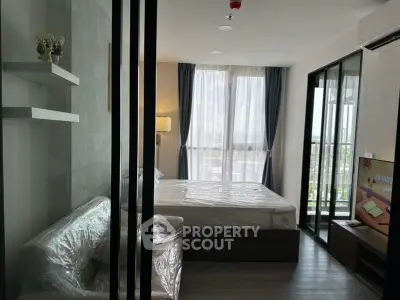 Modern bedroom with large windows and balcony access in a stylish apartment.