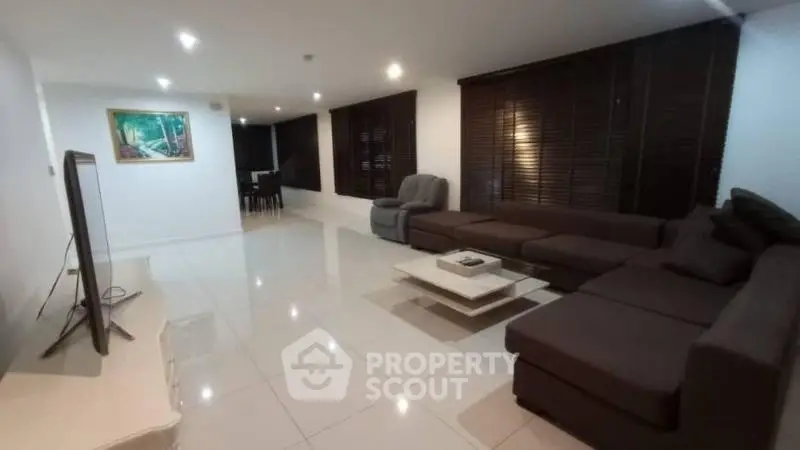 Spacious modern living room with sleek furniture and large windows.