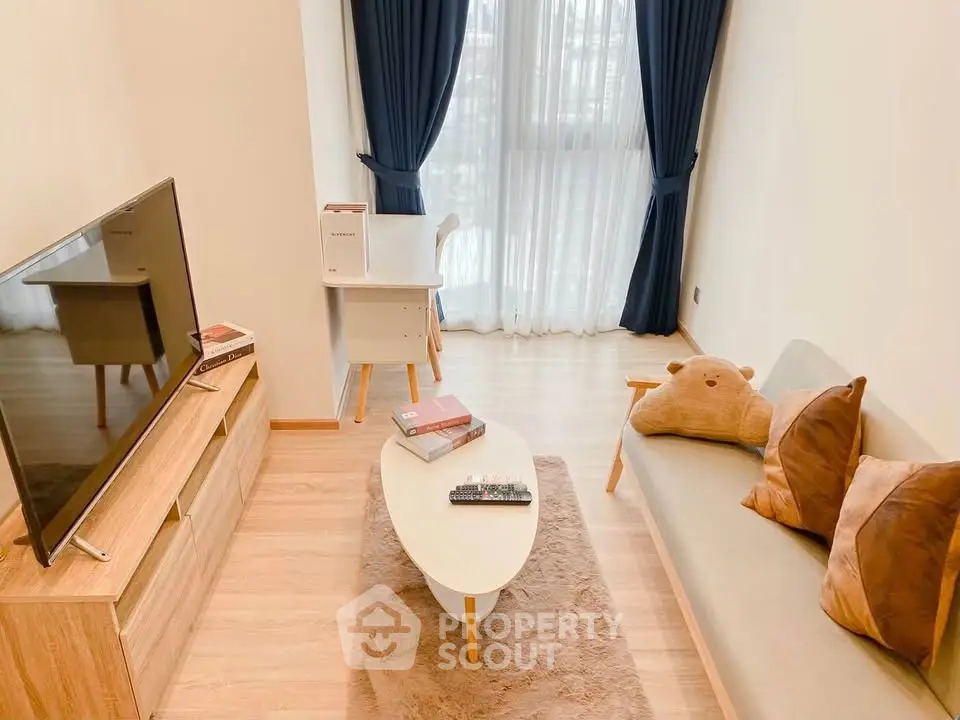Cozy living room with modern decor, wooden flooring, and natural light through large windows.
