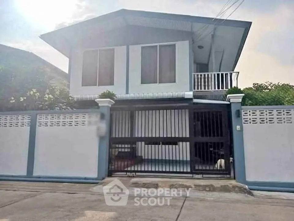 Charming two-story house with gated entrance and balcony in a serene neighborhood.