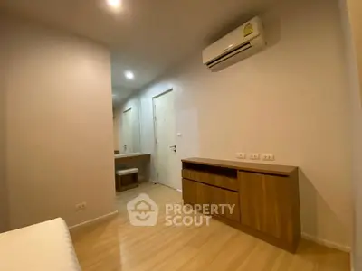 Modern bedroom with wooden flooring and built-in air conditioning unit