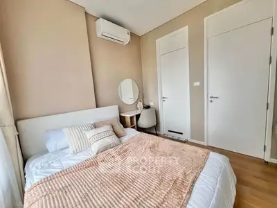 Cozy bedroom with modern decor and air conditioning, featuring a comfortable bed and stylish furniture.
