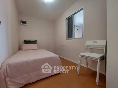 Cozy minimalist bedroom with single bed and stackable chairs, perfect for compact living.