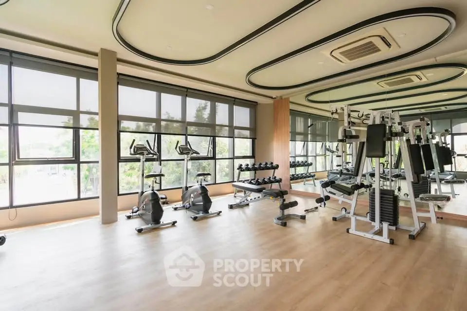 Spacious modern gym with large windows and state-of-the-art fitness equipment.