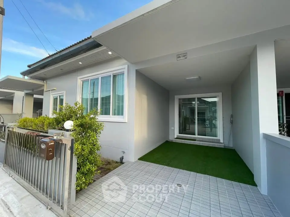 Modern single-story house with driveway and manicured garden