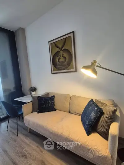 Modern living room with stylish sofa, artwork, and cozy lighting in a contemporary apartment.