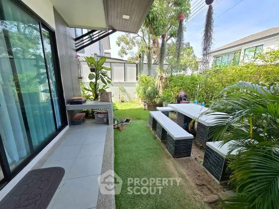 Charming garden area with modern outdoor seating and lush greenery, perfect for relaxation and entertaining.