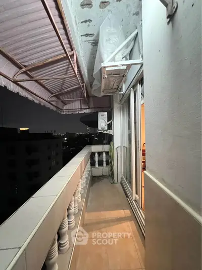 Charming balcony with city view and night ambiance, perfect for relaxation.