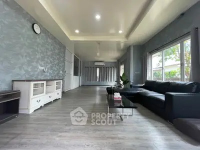 Spacious modern living room with elegant decor and large windows offering natural light.
