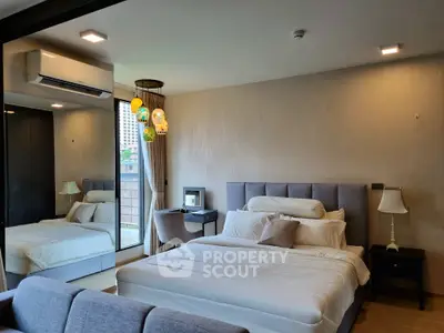 Luxurious bedroom with modern decor and large mirror reflecting natural light.