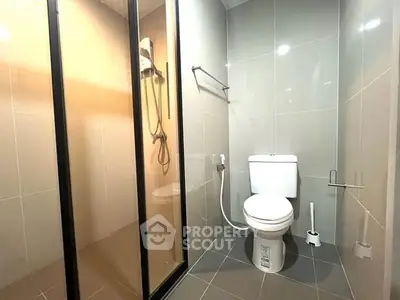 Modern bathroom with sleek shower and toilet in a contemporary apartment.