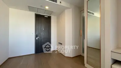 Minimalist entrance with wooden flooring and mirrored closet door