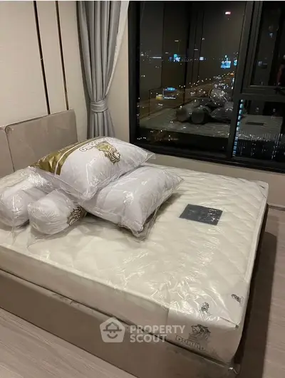 Modern bedroom with city view, featuring a plush bed and elegant curtains, perfect for urban living.