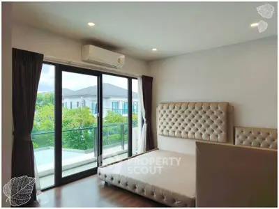 Spacious bedroom with large windows and balcony access in modern home