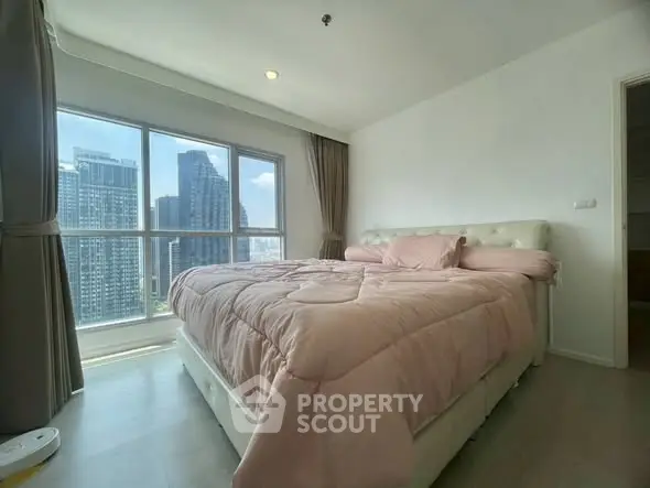 Spacious bedroom with city view and large windows in modern apartment