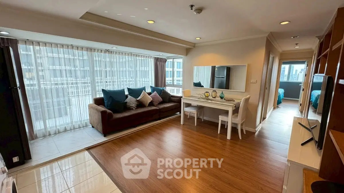 Spacious modern living room with large windows and stylish decor in a high-rise apartment.