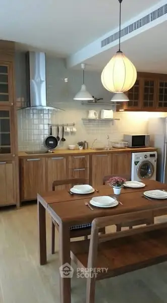 Charming kitchen with wooden cabinets, dining table, and modern appliances for a cozy home atmosphere.