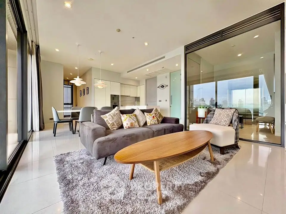 Luxurious modern living room with open layout and city view, featuring stylish furniture and elegant decor.