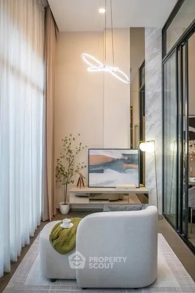 Modern living room with high ceilings, stylish furniture, and elegant lighting in a luxury apartment.