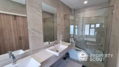 Modern bathroom with dual sinks and glass shower enclosure