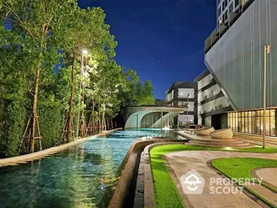 Luxurious modern apartment with stunning pool and lush greenery at night