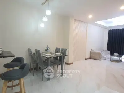 Spacious modern living room with dining area and elegant lighting in a stylish apartment.