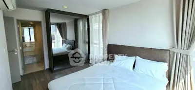 Modern bedroom with large mirror and ensuite bathroom in a stylish apartment.