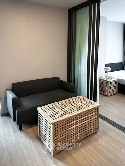 Modern living room with sleek sofa and stylish wooden coffee table in a cozy apartment setting.