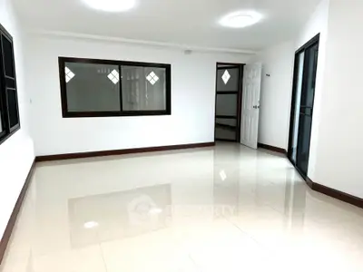 Spacious empty room with large windows and glossy tiled floor