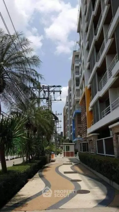 Modern apartment building exterior with landscaped walkway and palm trees