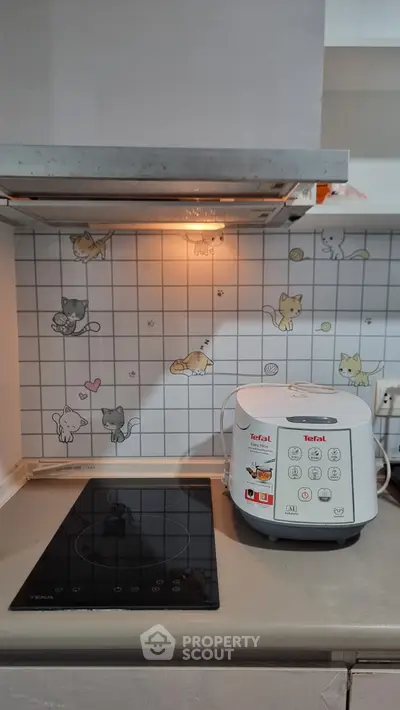 Charming kitchen with cat-themed backsplash and modern appliances