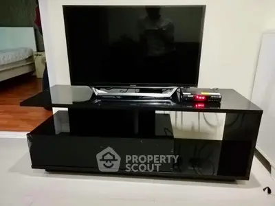 Modern living room with sleek black TV stand and flat-screen TV