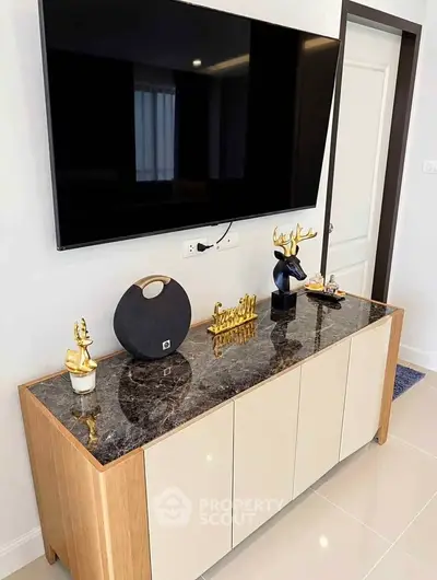 Modern living room with sleek TV setup and stylish decor on marble-top console.