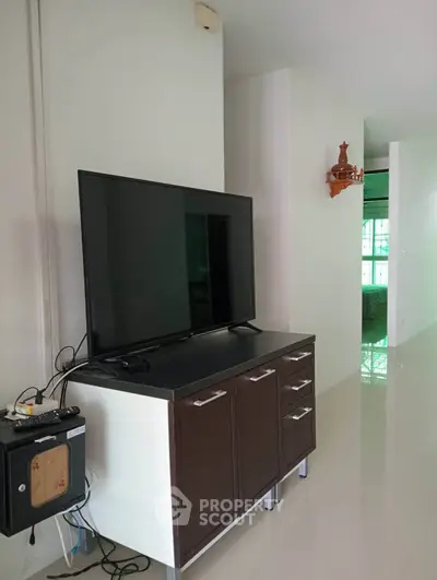 Modern living room with sleek TV stand and flat-screen TV, showcasing minimalist design.