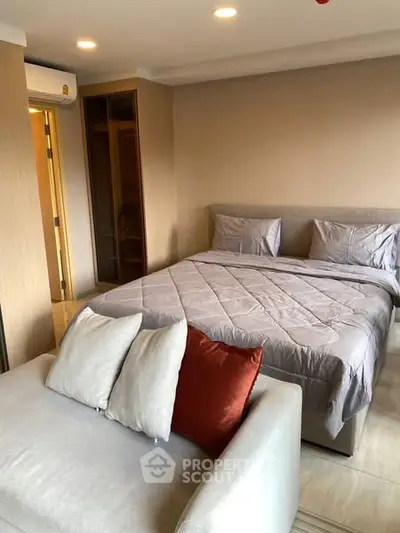 Cozy bedroom with modern decor and comfortable bedding in a stylish apartment.