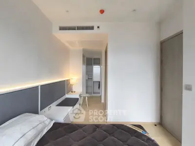 Modern bedroom with sleek design and cozy lighting, featuring a built-in wardrobe and minimalist decor.