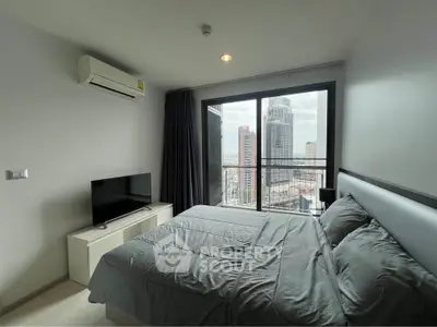 Modern bedroom with city view, featuring sleek furniture and large window for natural light.