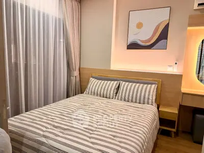 Cozy bedroom with modern decor and natural light, featuring a comfortable bed and stylish artwork.