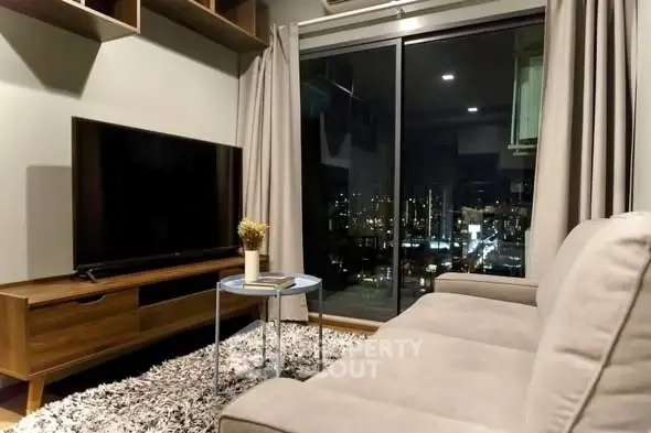 Modern living room with city view, cozy sofa, and large TV, perfect for relaxation.