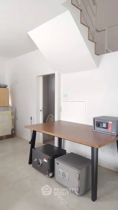 Spacious room with modern safes under a wooden table, showcasing security features in a contemporary home.