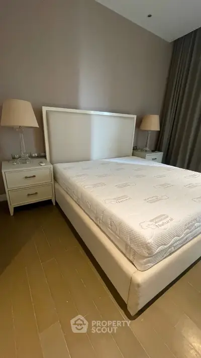 Spacious bedroom with elegant bed and stylish nightstands, perfect for a cozy retreat.