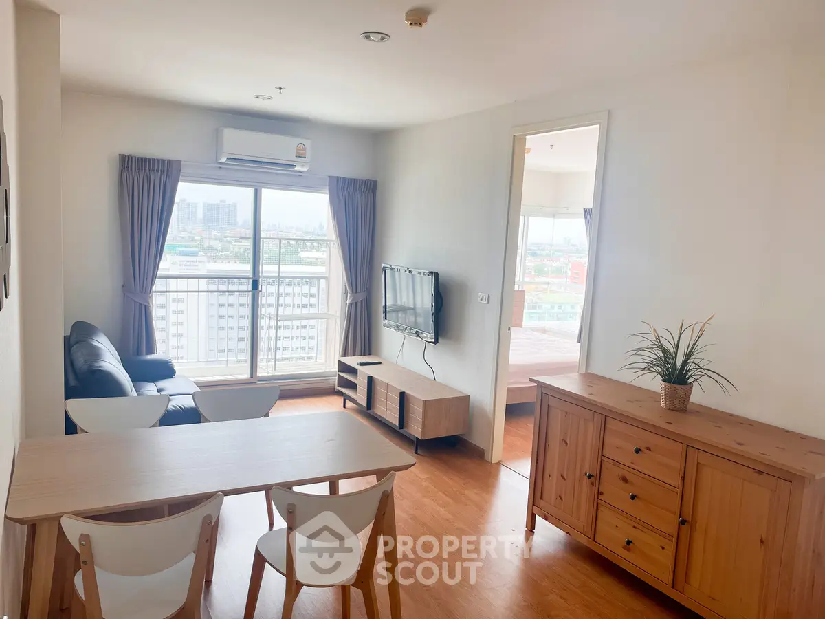 Bright and airy living room with city view, modern furniture, and wooden flooring in a high-rise apartment.