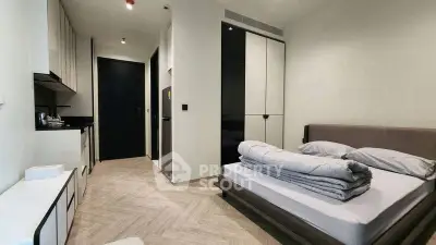 Modern bedroom with sleek design and compact kitchen area, perfect for urban living.