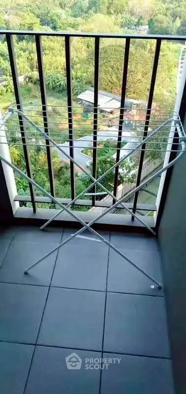 Charming balcony with scenic view and practical drying rack, perfect for urban living.