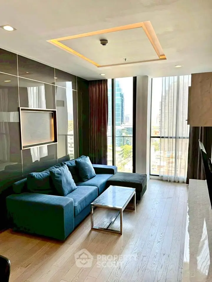 Modern living room with city view, featuring sleek design and comfortable seating in a high-rise apartment.
