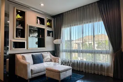 Elegant living room with plush sofa, large window, and stylish decor
