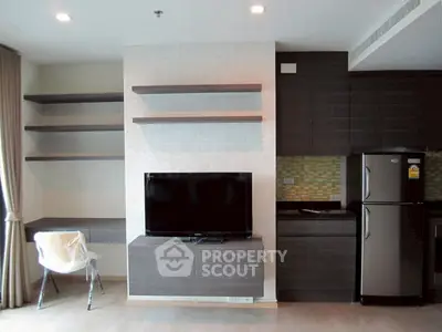Modern living room with sleek TV unit and stainless steel fridge in open layout.